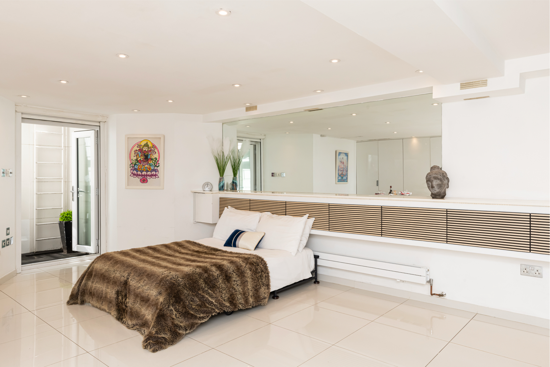 Spacious main bedroom with soft furnishings